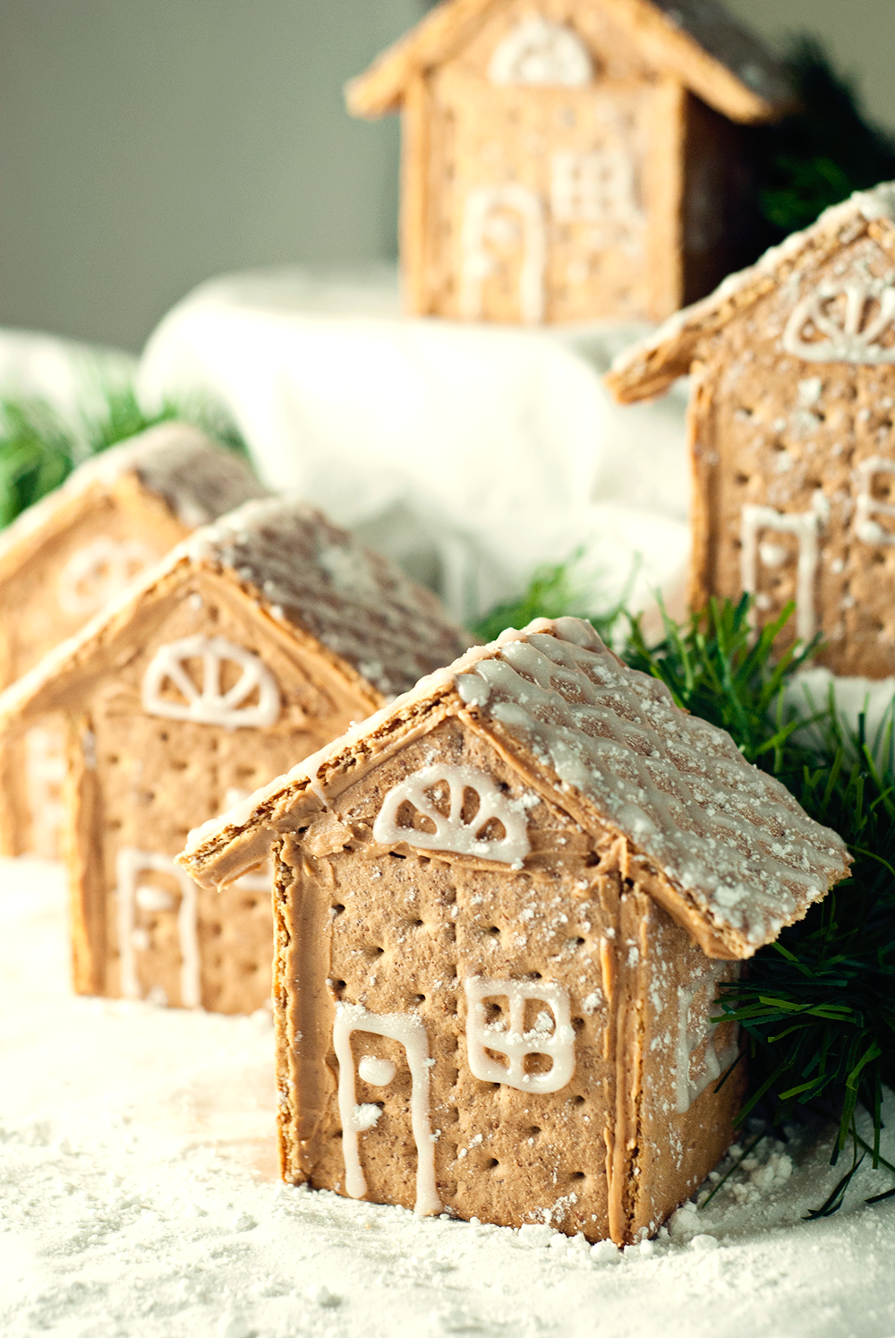 Gorgeous Graham Cracker House Village that is so easy to make with peanut butter and decorated with sparkle gel icing and powdered sugar!