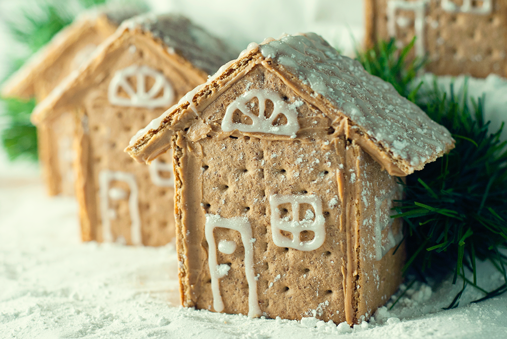 Gorgeous Graham Cracker House Village that is so easy to make with peanut butter and decorated with sparkle gel icing and powdered sugar!