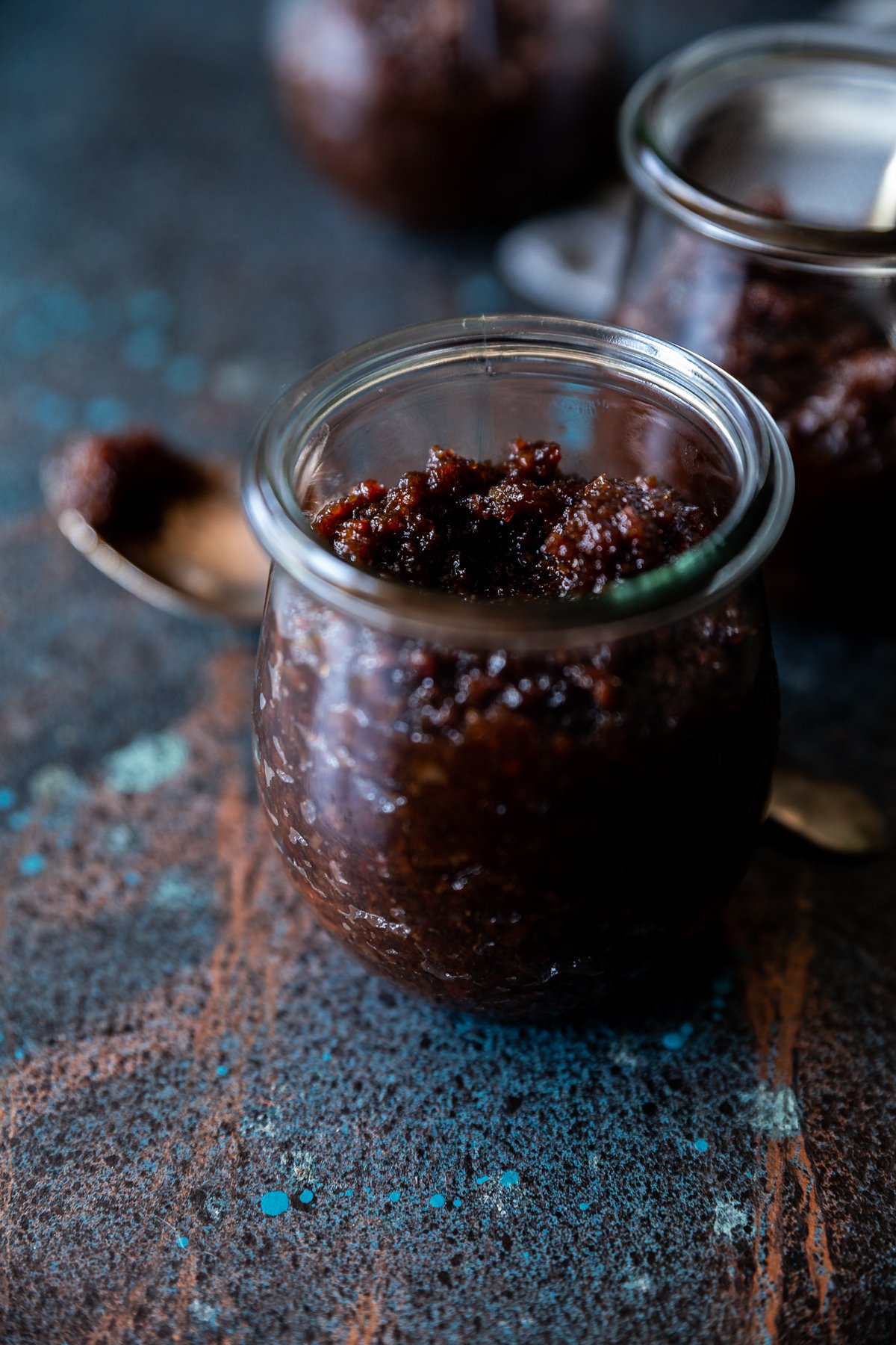 Bacon jam in small tulip jars, spoon with bacon jam on it