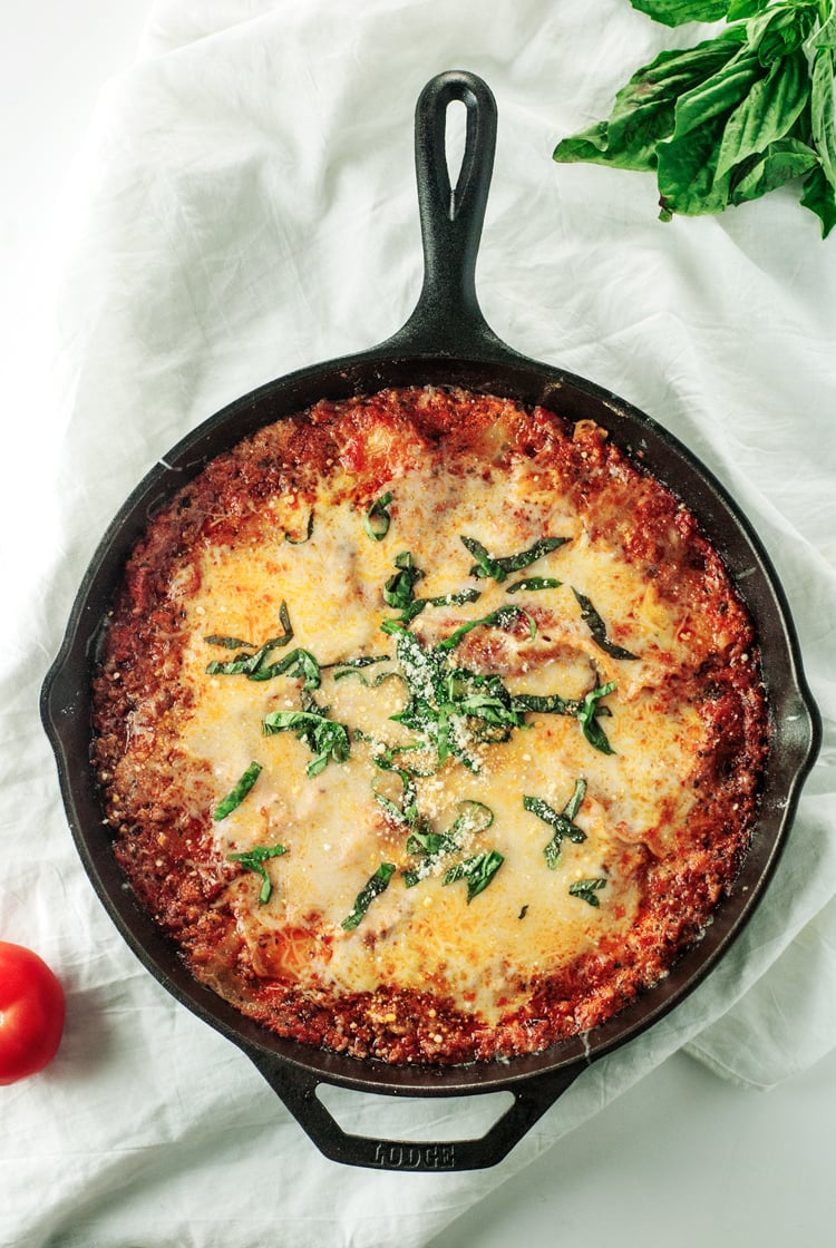 Cast iron skillet filled with cheesy lasagna