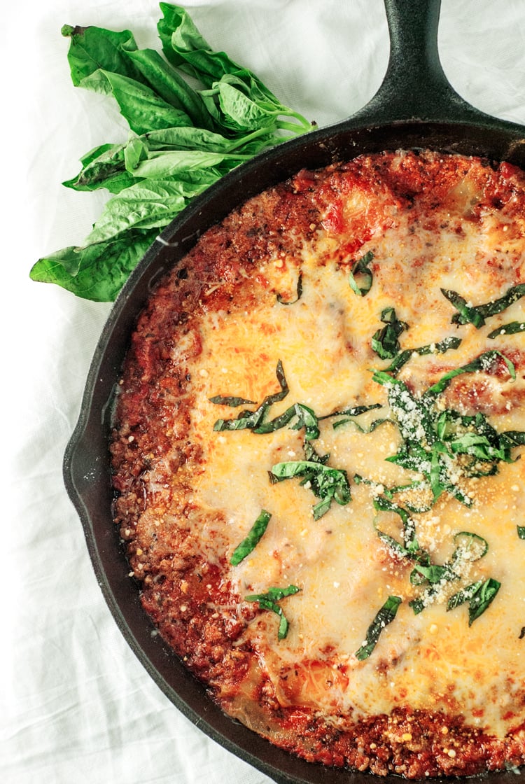 Cast iron skillet filled with cheesy lasagna