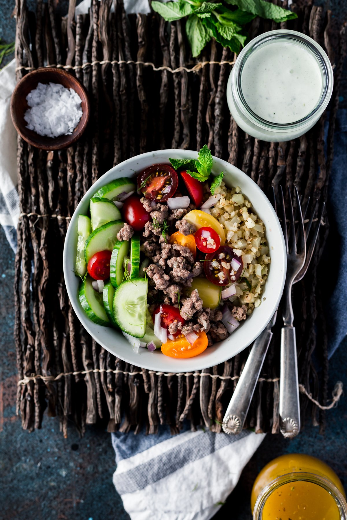 gluten free greek lamb bowls with cauliflower riced veggies, cucumbers, greek dressing, and tzatziki sauce