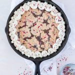 Cast iron skillet brookie with vanilla frosting and funfetti sprinkles.