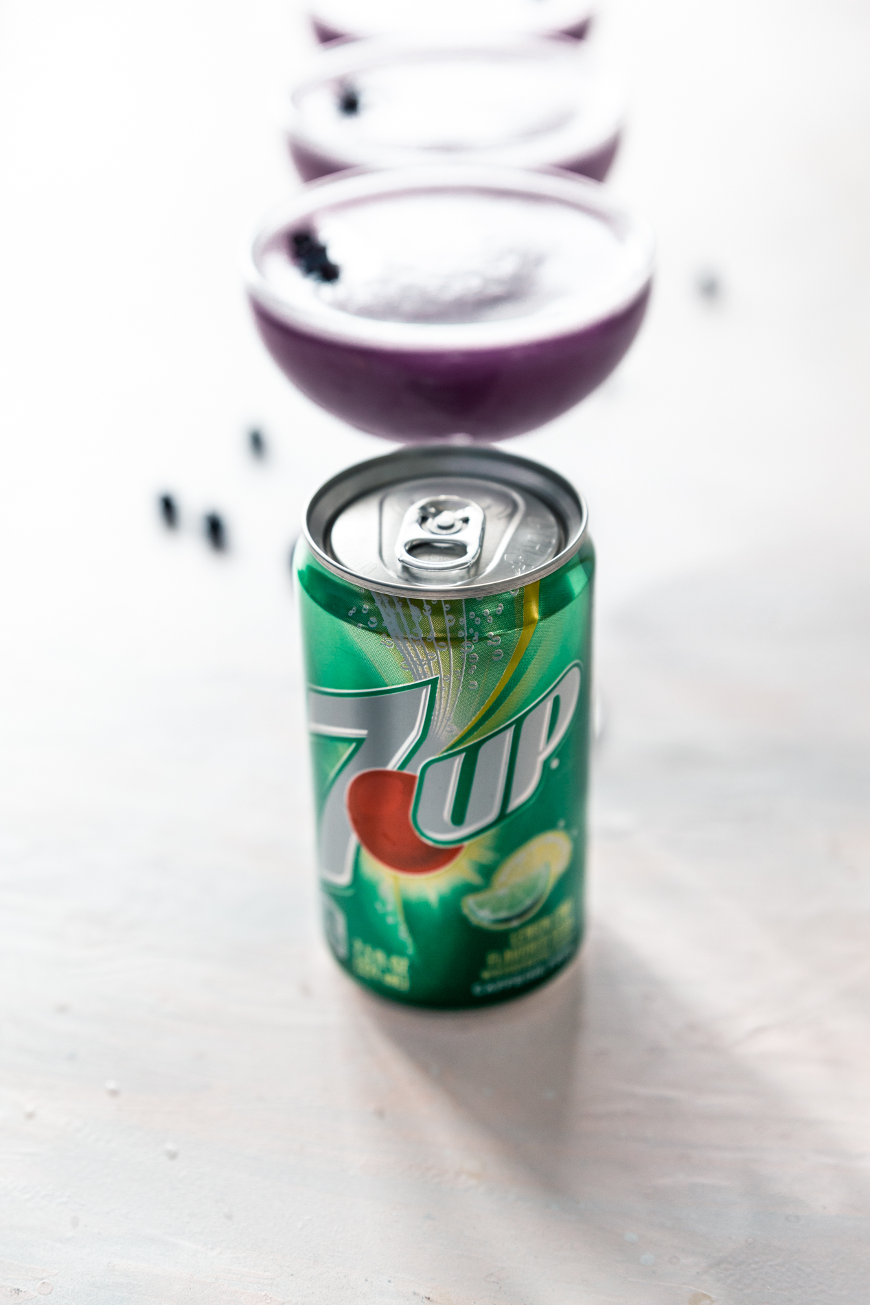 side view of a row of blueberry clover club cocktails with a small can of 7up in front by minnesota food blogger asimplepantry