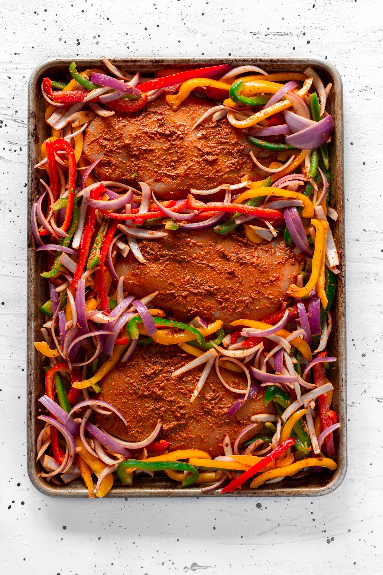 overhead view of chipotle sheet pan chicken fajitas before going in the oven.
