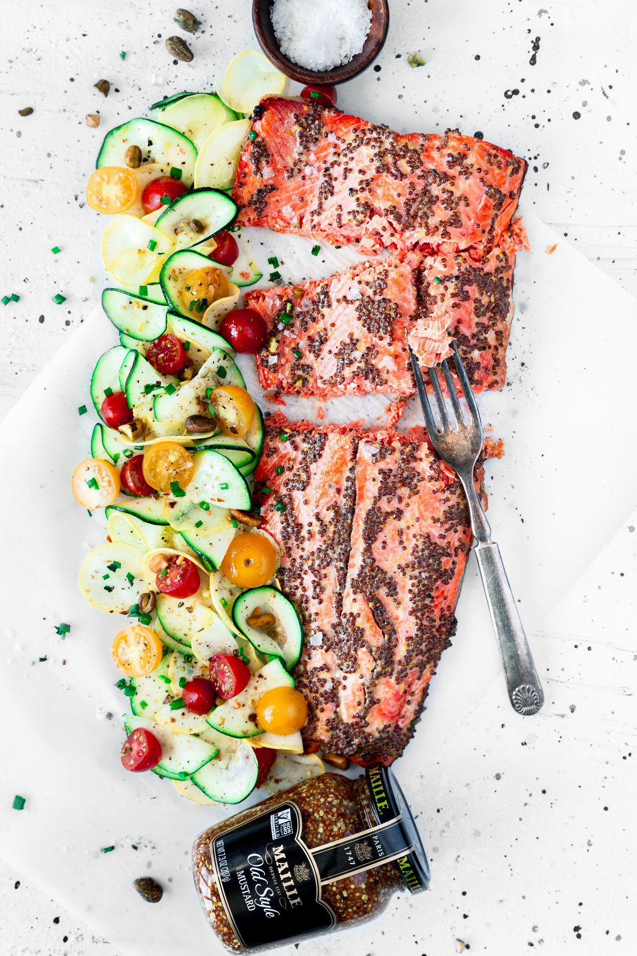 overhead view of mustard salmon with citrus squash salad and a jar of mustard and fork