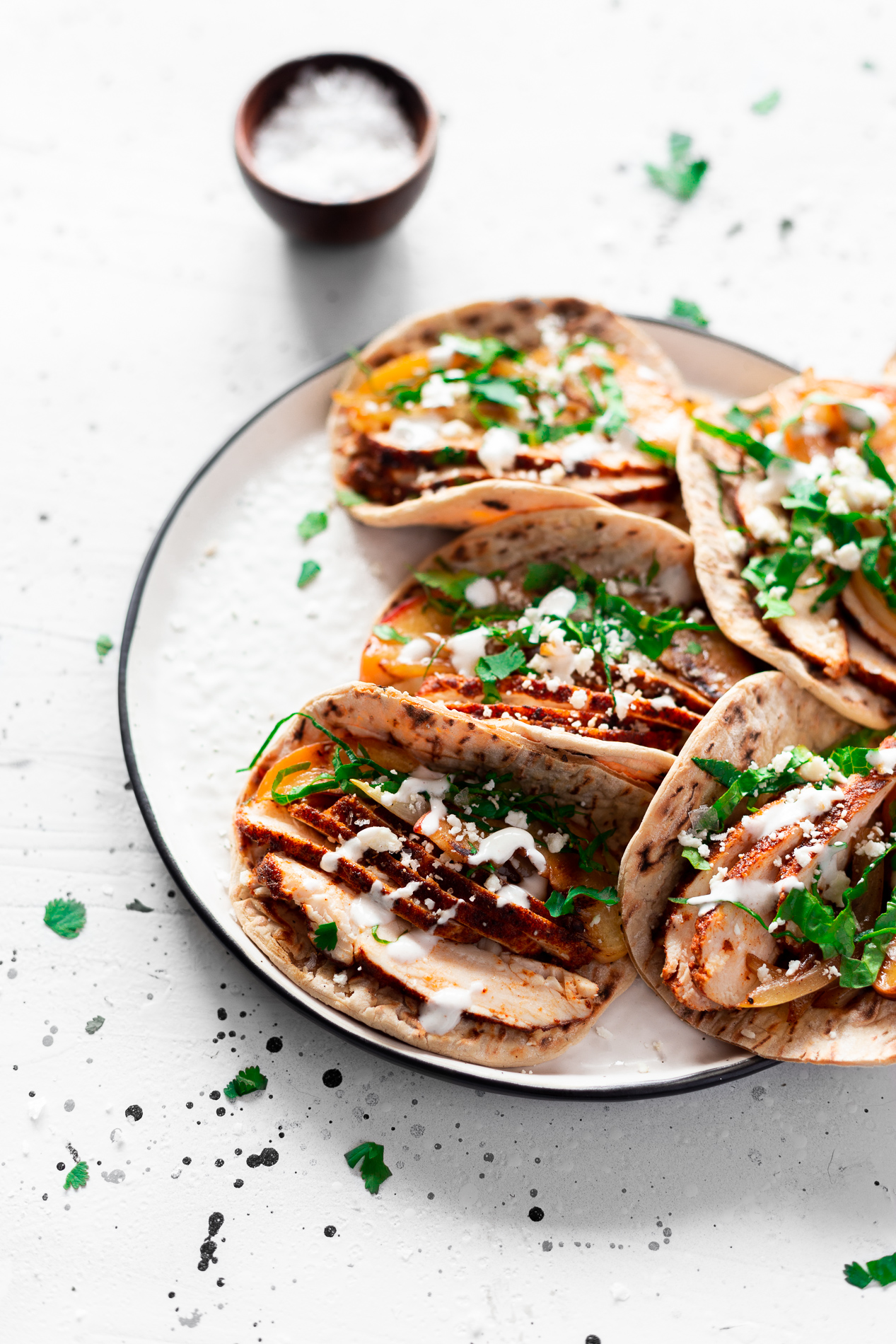 angled view of a plate of harissa chicken tacos with spiced yogurt sauce