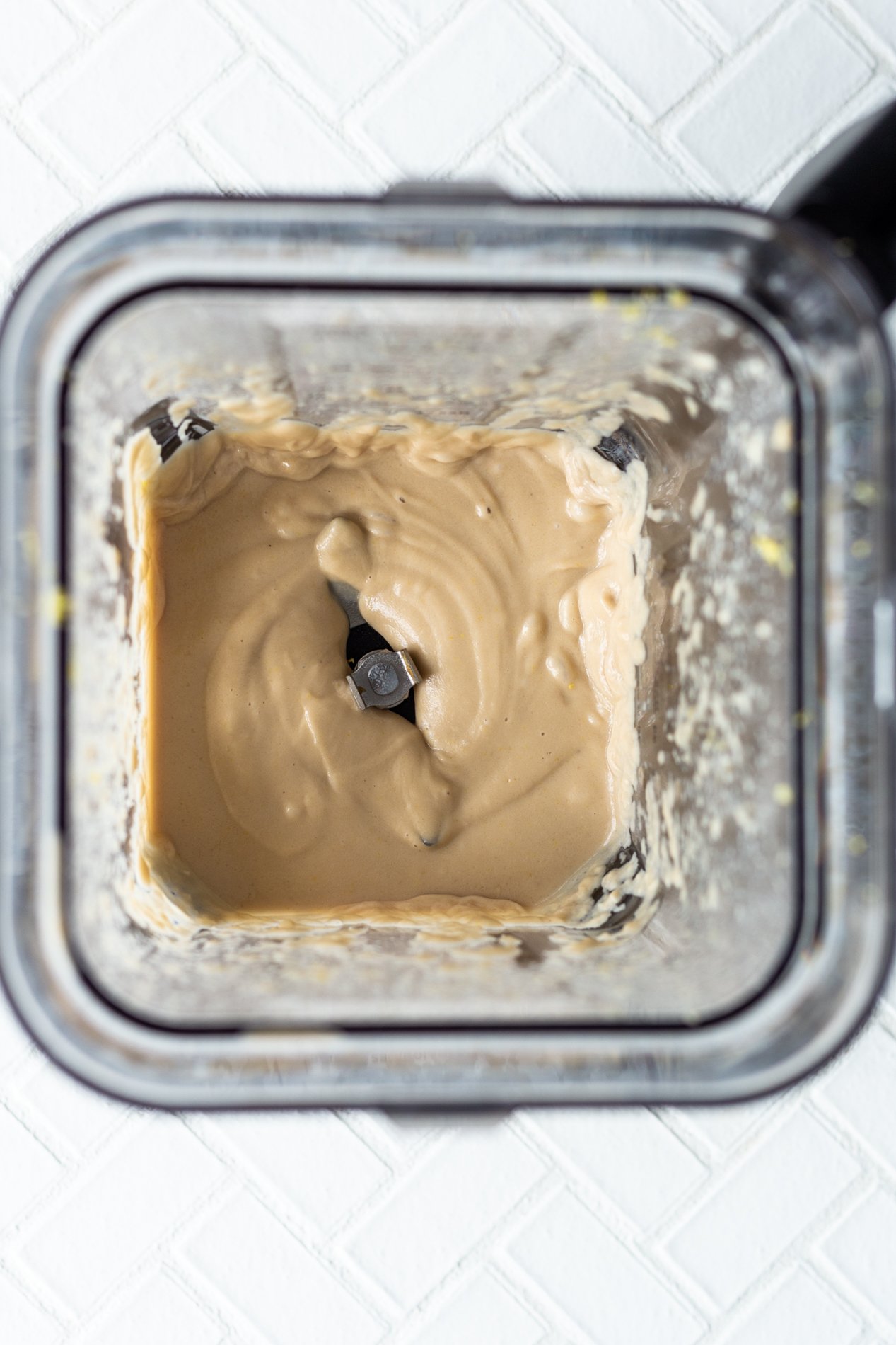 overhead view into a blender with vegan lemon cheesecake mix inside