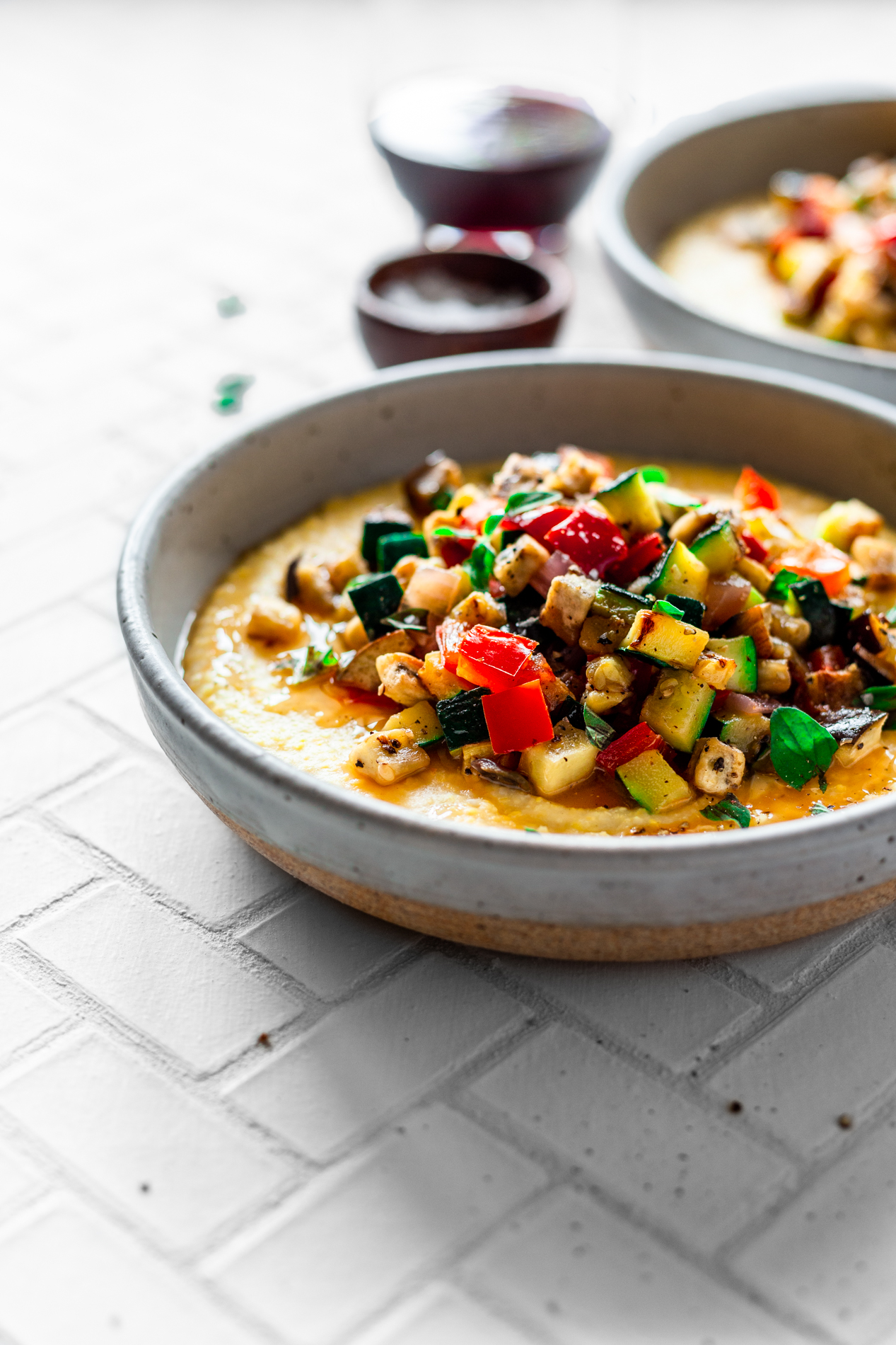 angled view of a bowl of easy ratatouille recipe with creamy polenta