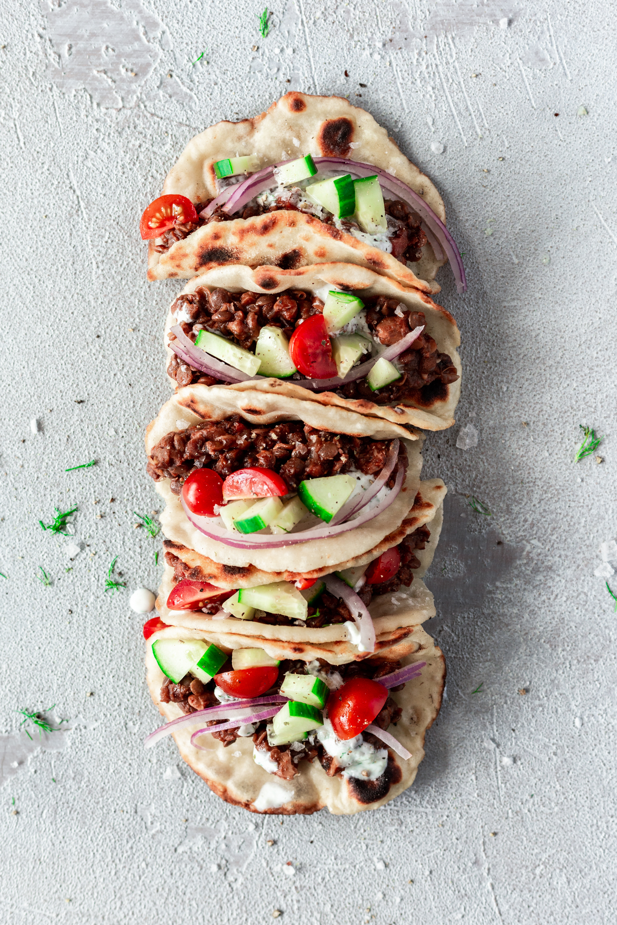 overhead view of instant pot vegan gyro recipe in naan wraps lined up in a row