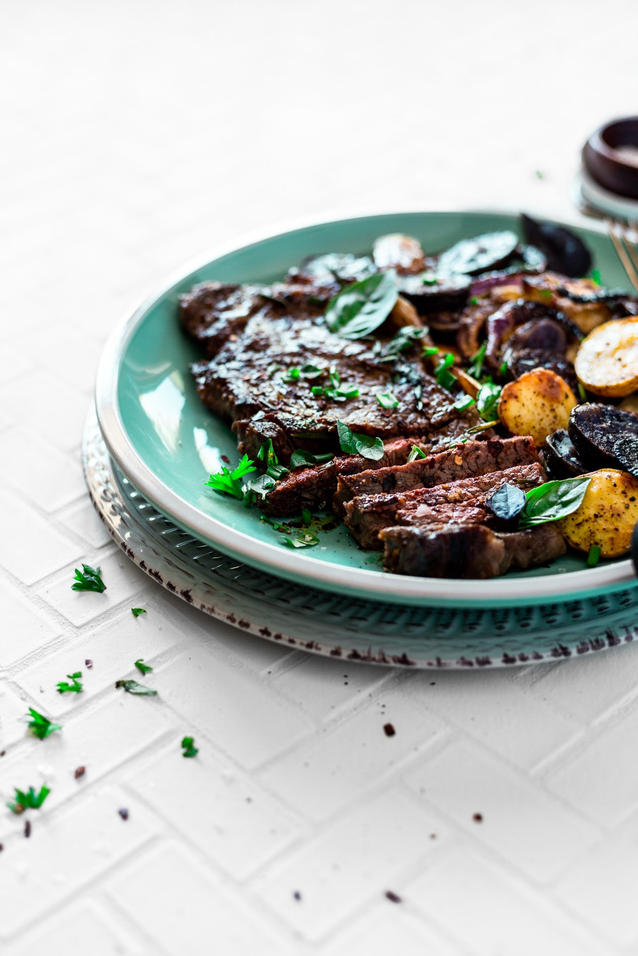 angled view of chipotle herb pan seared steak recipe with roasted potatoes