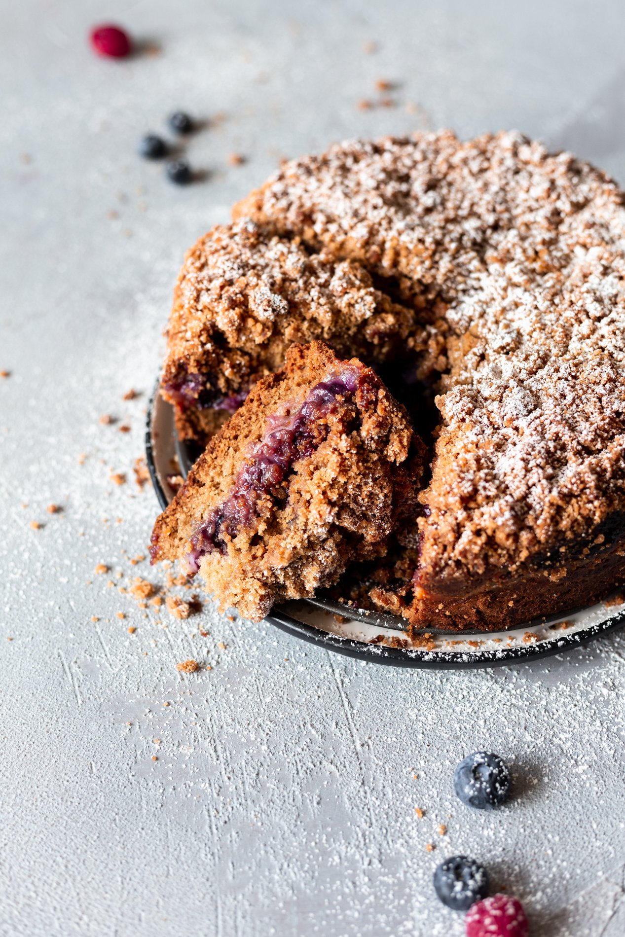 angled view of triple berry vegan coffee cake recipe with a slice cut out