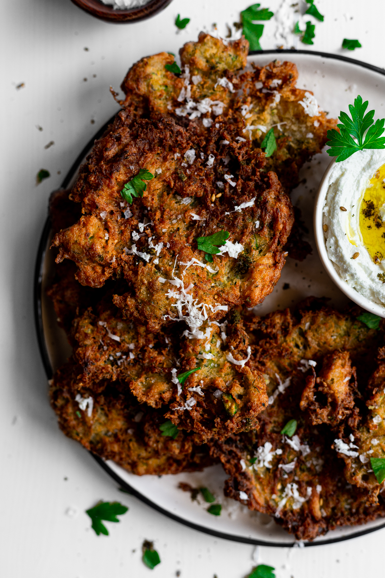 closeup overhead view of a plate of za'atar spiced zucchini fritters with homemade labneh