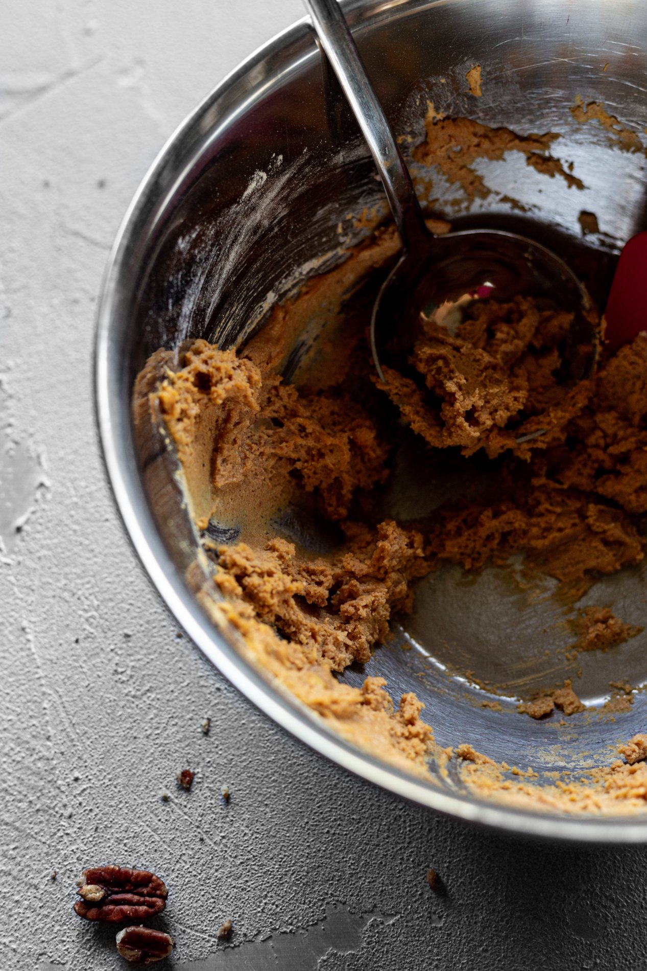a nearly-empty bowl of pumpkin bread griddle cake batter with spoon inside