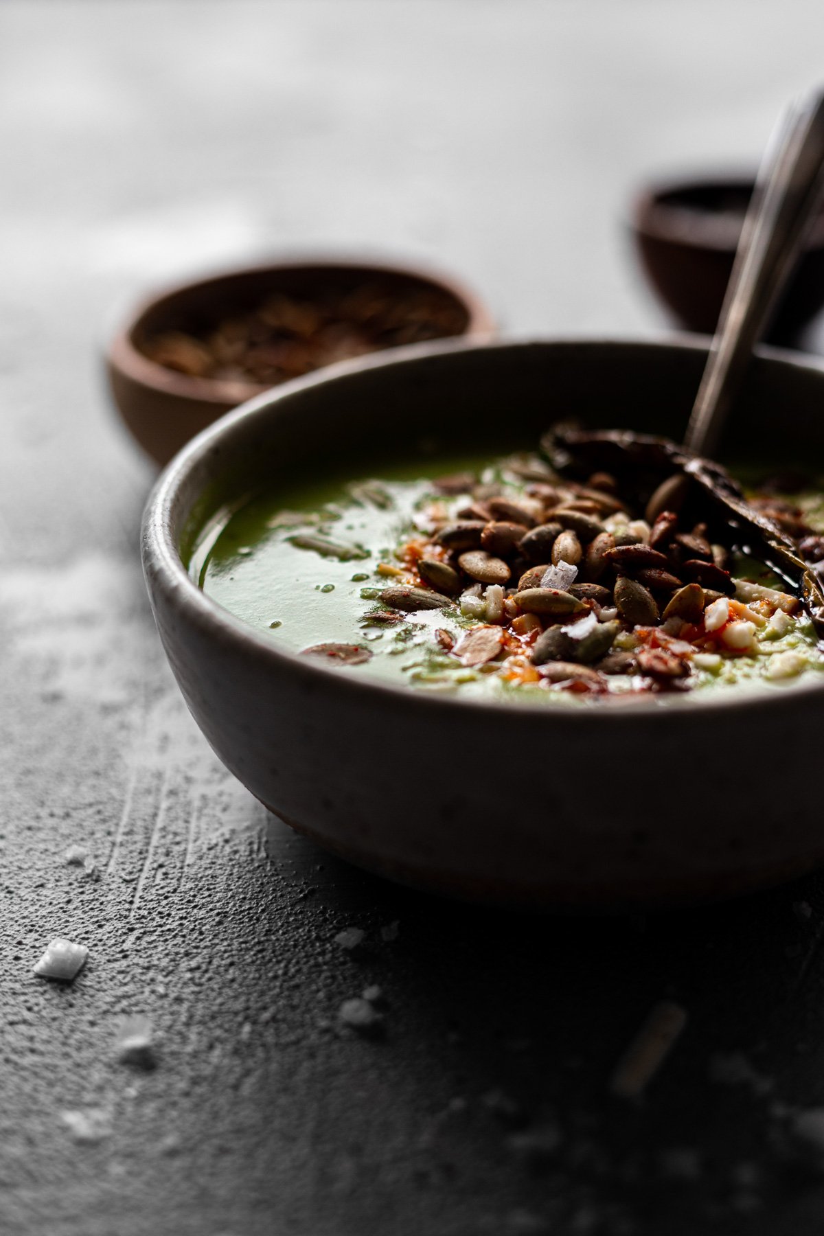 bowl of gluten free and vegan poblano zucchini soup with chili-lime pepitas