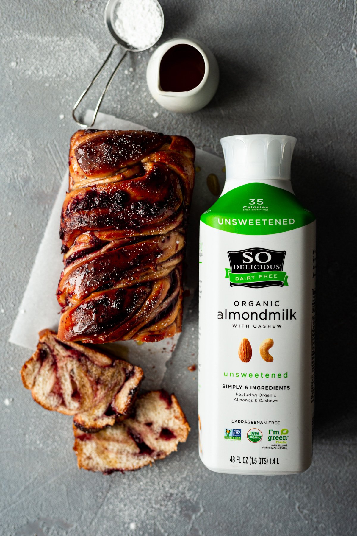 vegan lingonberry babka loaf and bottle of So Delicious Dairy Free Almondmilk with Cashew