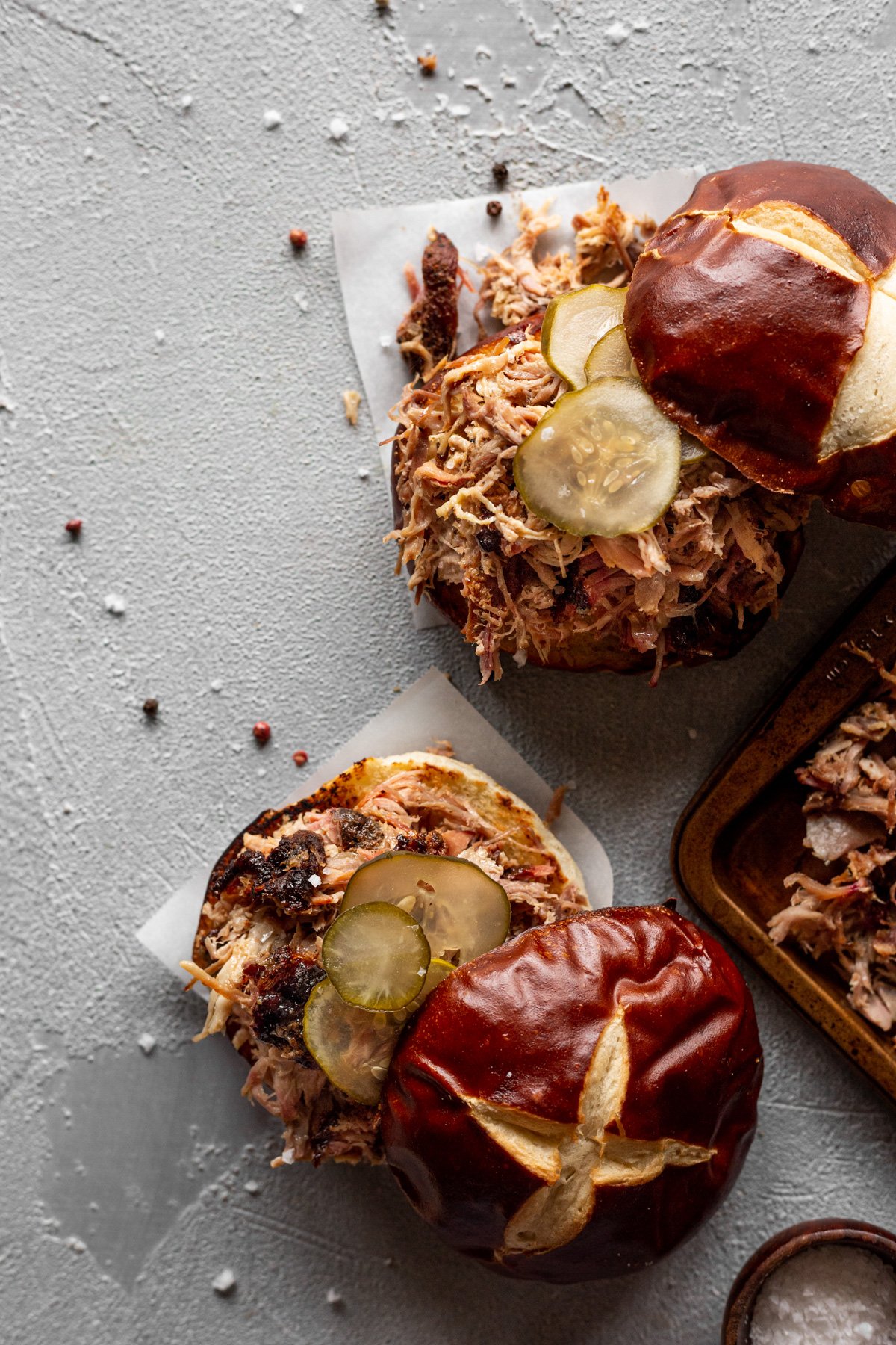 smoked pulled pork on pretzel buns with pickles