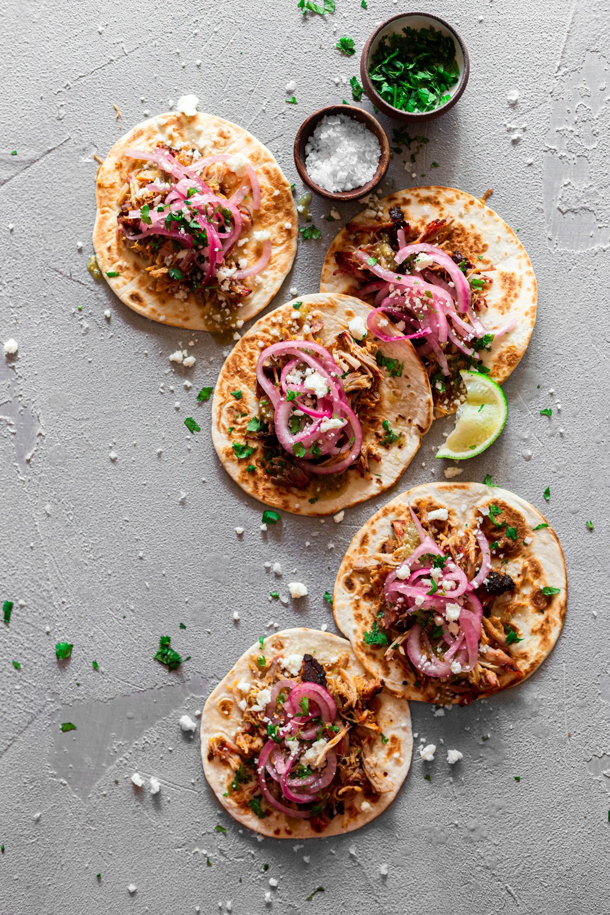 five cochinita pibil tacos with pickled red onion and salsa verde