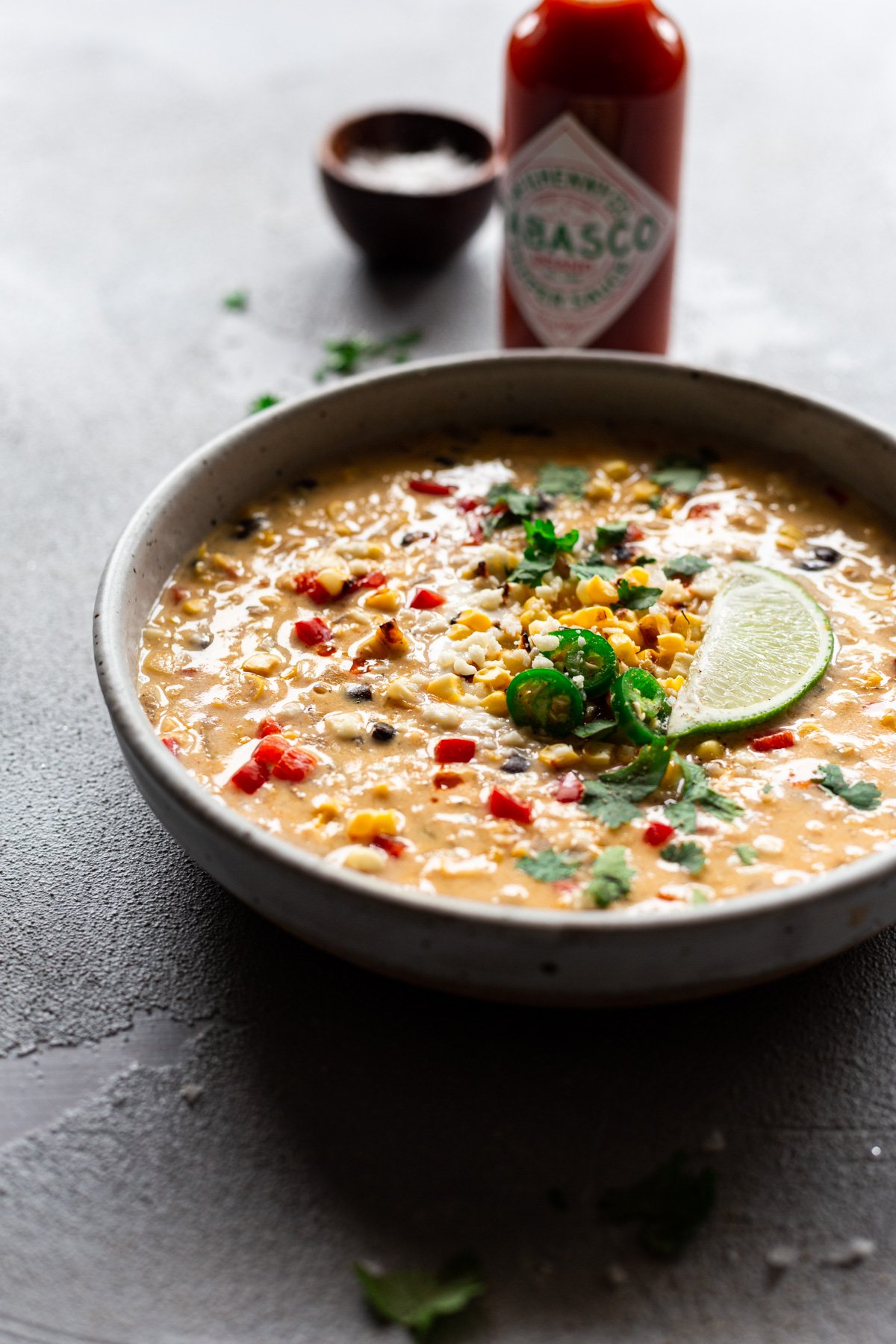 bowl of easy mexican street corn chowder with a bottle of TABASCO® Sauce in the background
