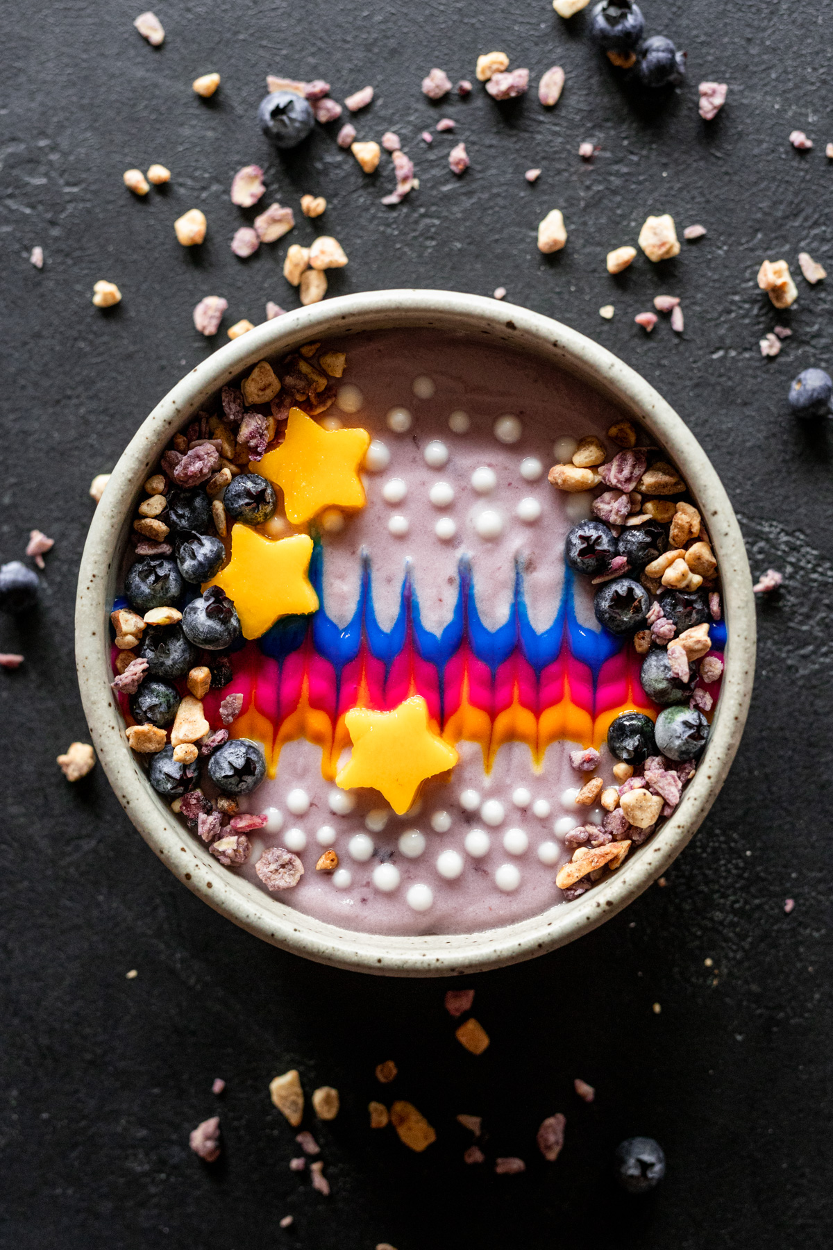 Tie-Die Yogurt Smoothie Bowl with star-shaped mango pieces and fresh blueberries