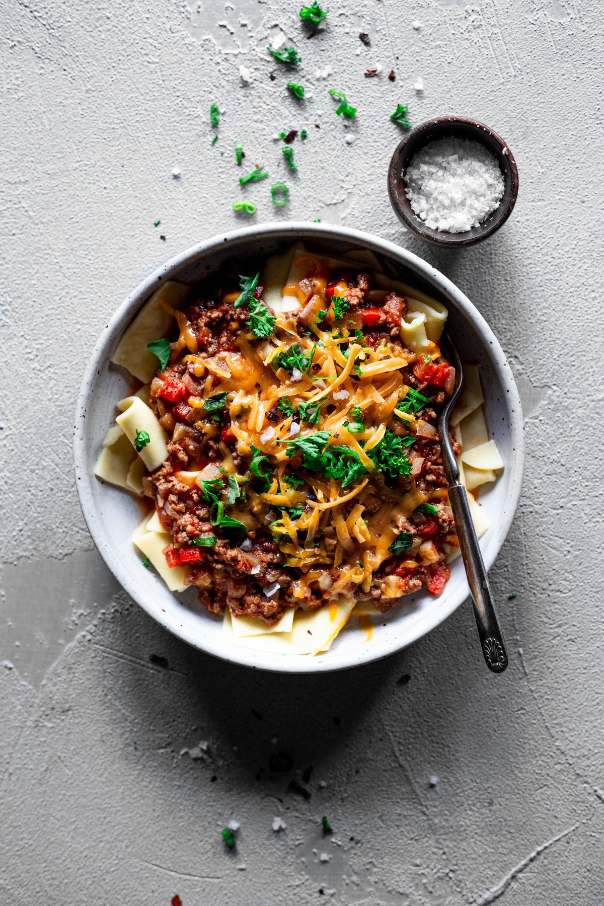 easy weeknight meat sauce topped with scallions, parsley, and cheddar cheese