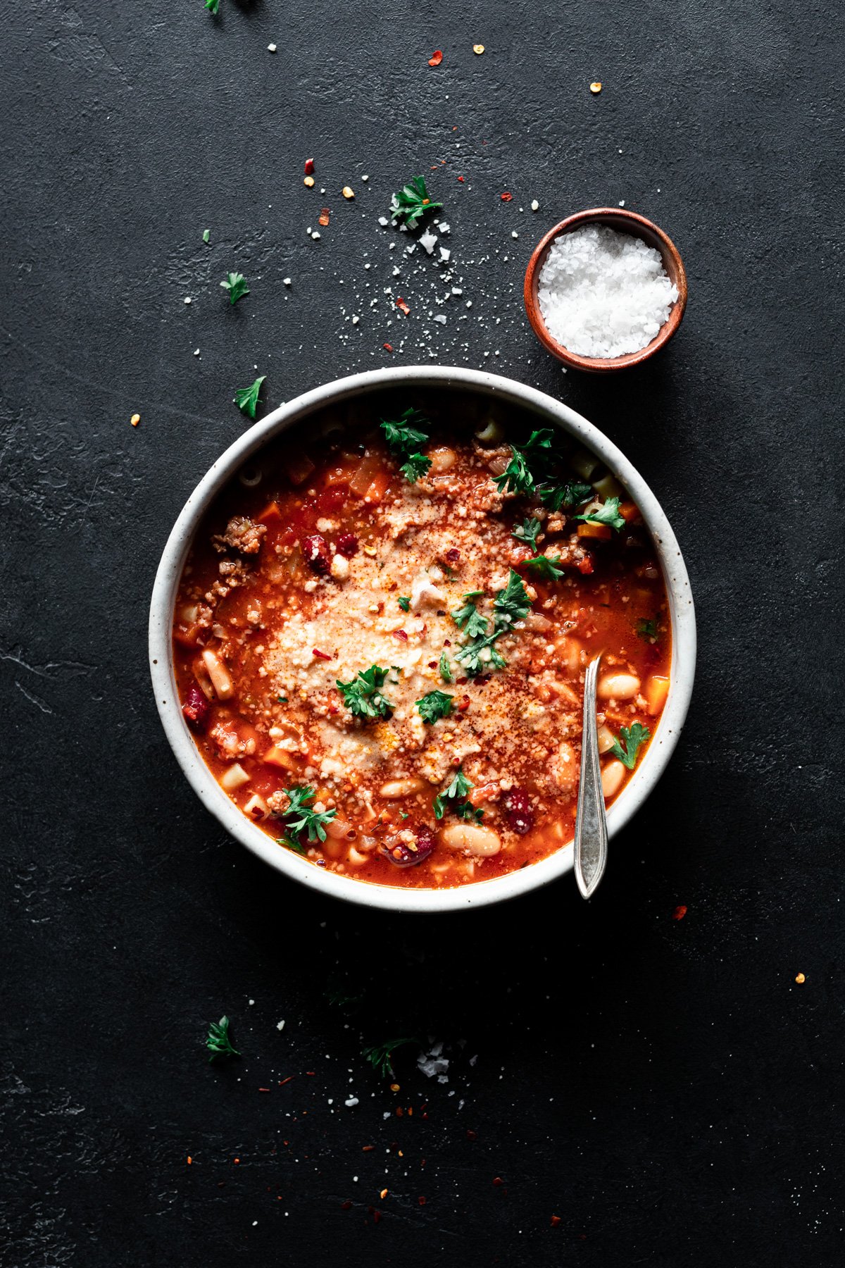 bowl of pasta e fagioli with parmesan and fresh parsley on top