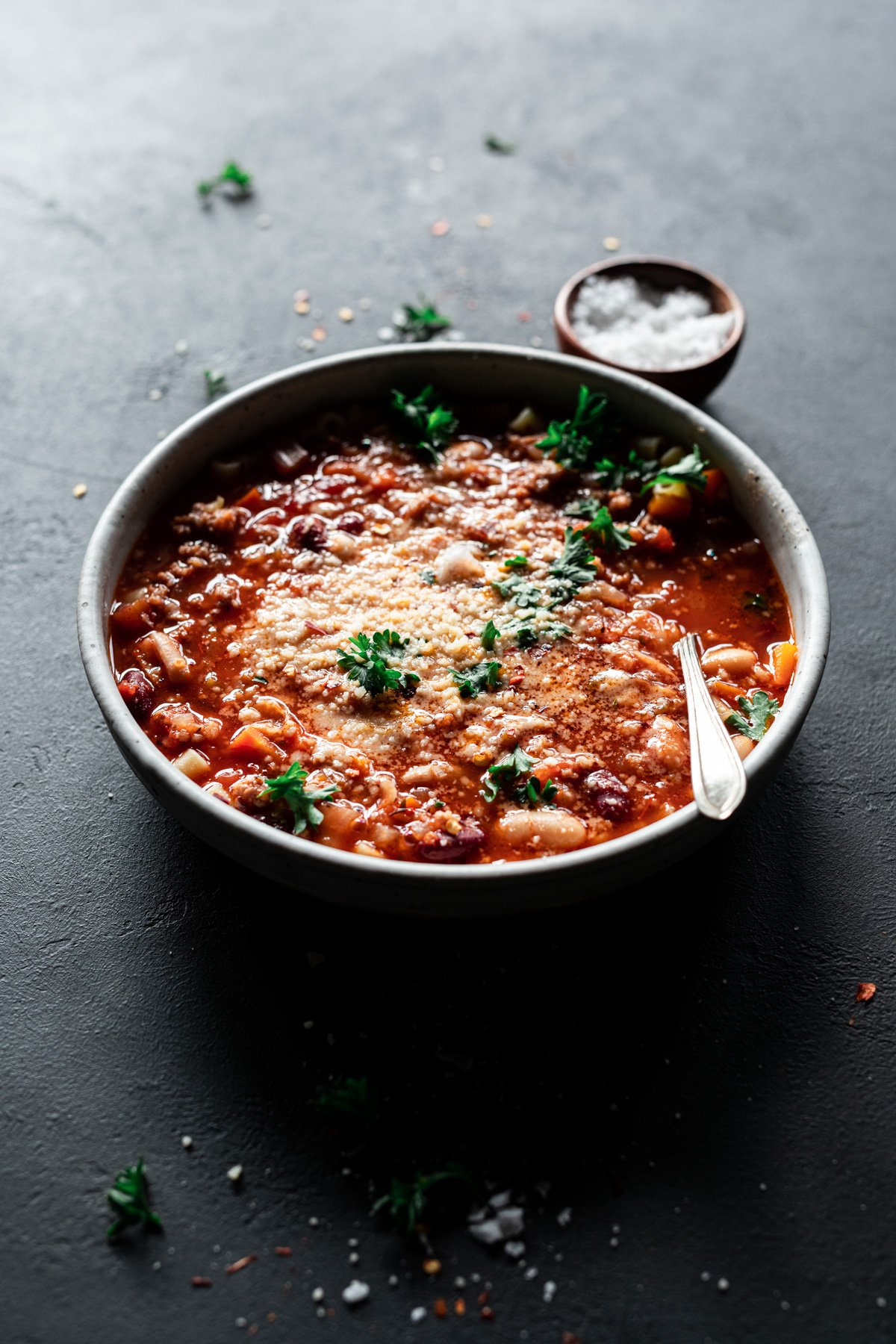 pasta e fagioli recipe in a bowl with parmesan and parsley