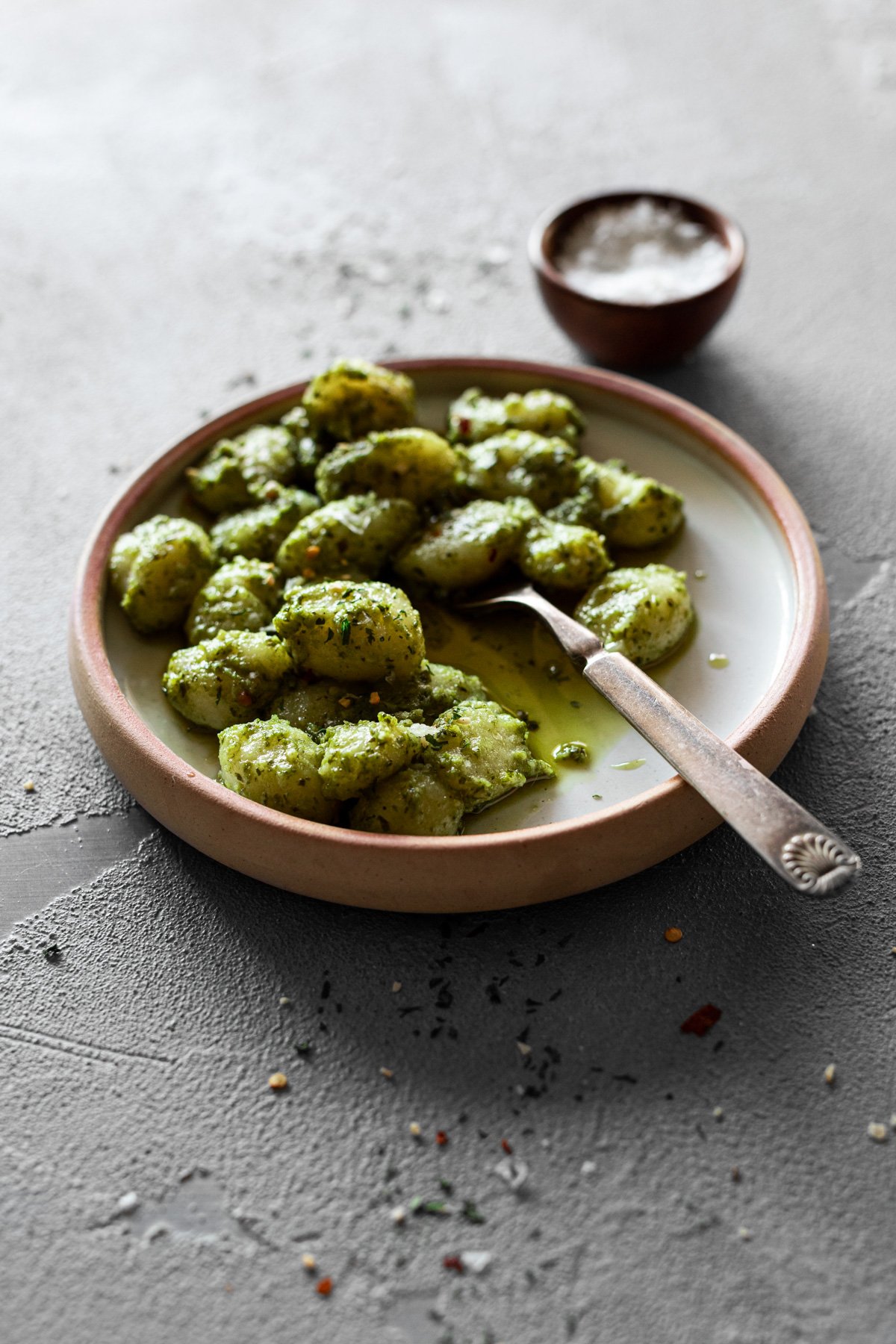 plate with pesto gnocchi and a fork