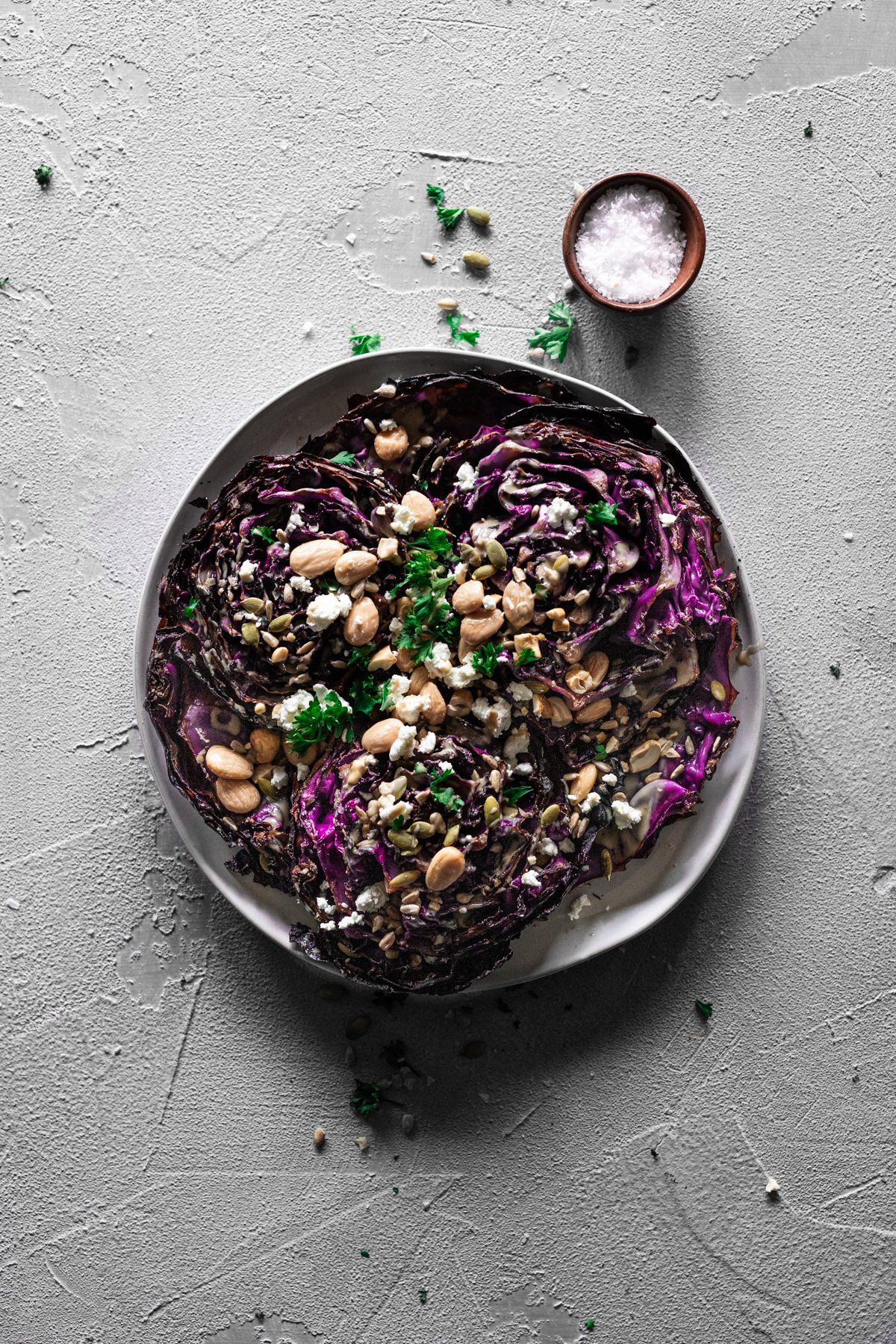 roasted red cabbage with tahini, goat cheese, nuts and seeds on a plate