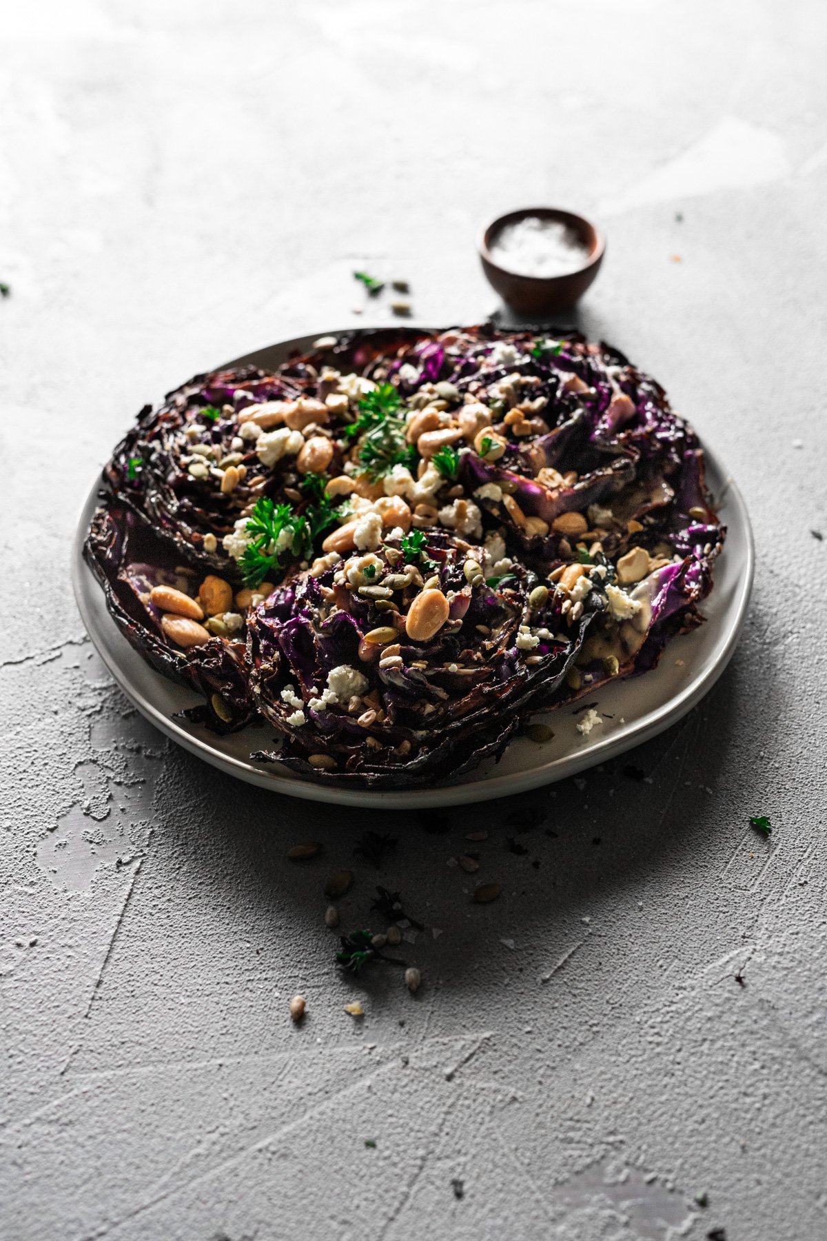 roasted red cabbage with tahini, goat cheese, nuts and seeds on a platter