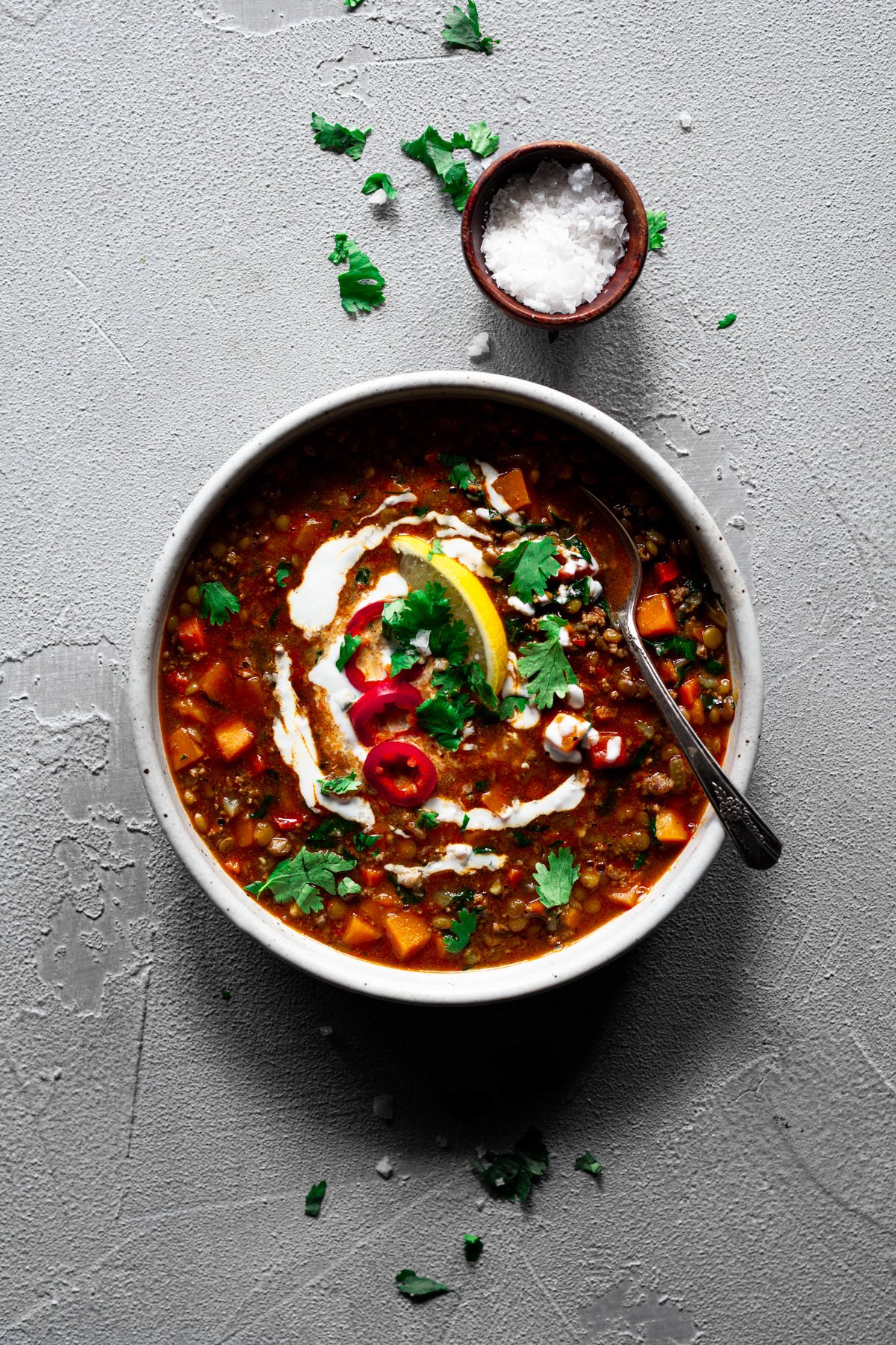 bowl of mediterranean lentil soup with greek yogurt, chiles, and fresh cilantro